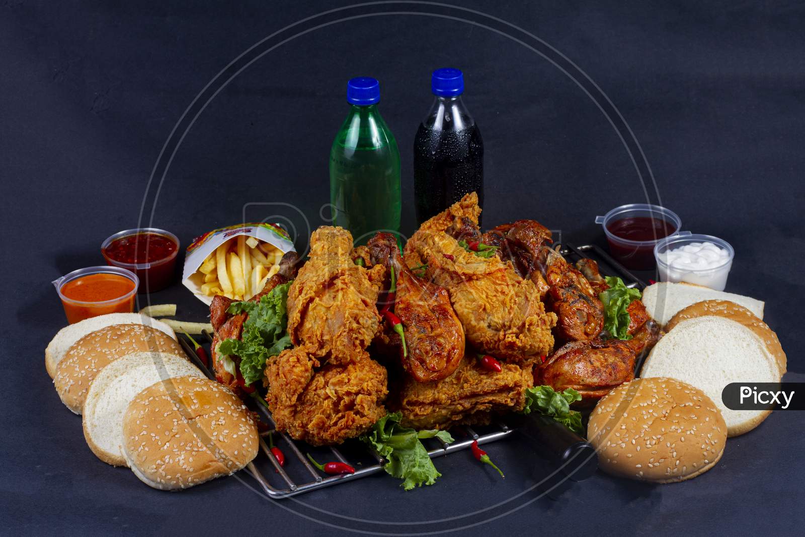 Hot And Crispy Fried Chicken Legs And Grilled Chicken Legs Isolated On A Grill Platter.French Fries, Cold Drink And In Background