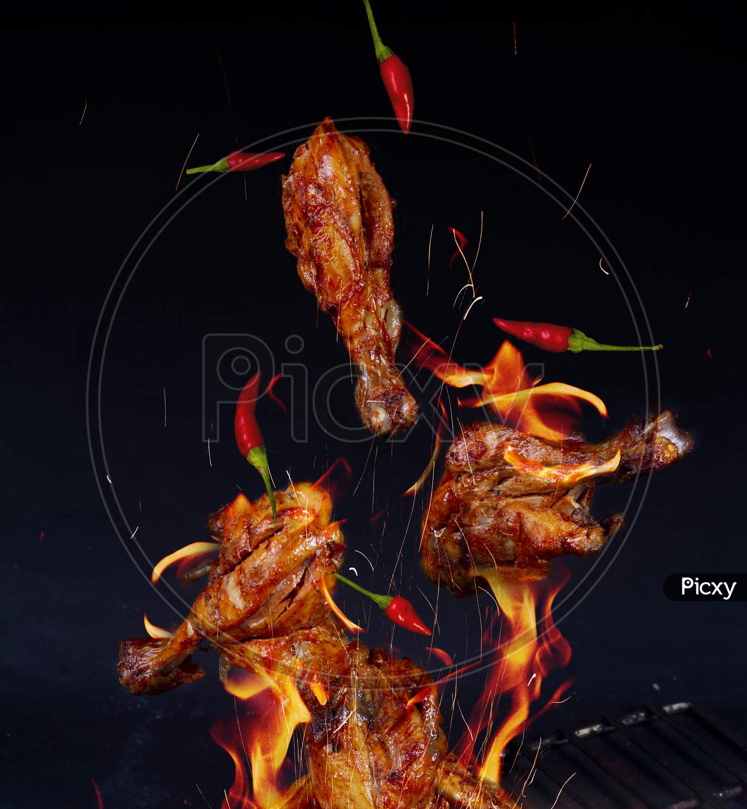 Flying Pieces Of Grilled Chicken Leg Pieces On Grill Grid, Isolated On Black Background. Concept Of Flying Food.