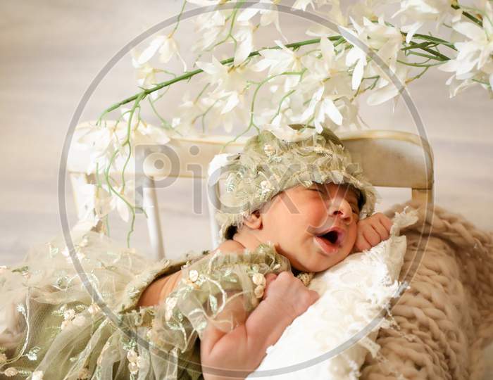 Cute Baby Girl Laying On Tiny Bed In The Shade Of Flowers Closeup White Pillow Beautiful Dressing
