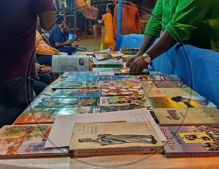 A group of people selling books in a book stall during Durga puja in kolkata, India. Selective focus on books.