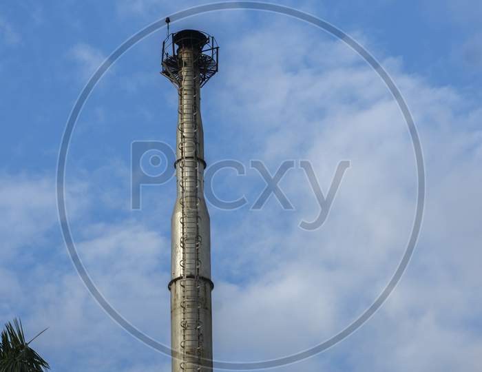A Non Working Industrial Factory Chimney Without Smoke Against The Blue Sky. Environmental Pollution Concept. Text Copy Space.