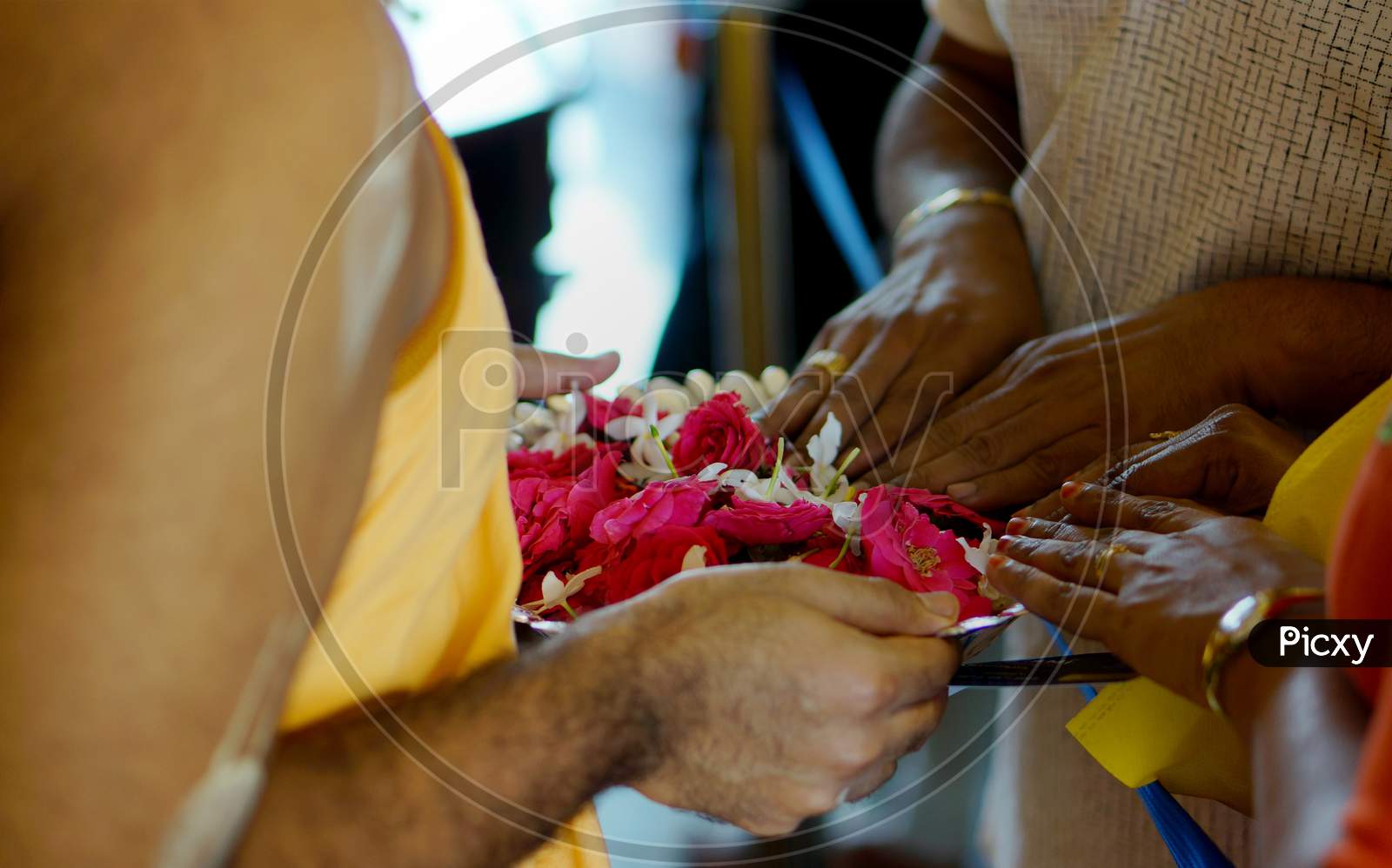Indian Hindu People Touch The Flowers Which Are To Be Used In Offering Prayers  To God By The Priest