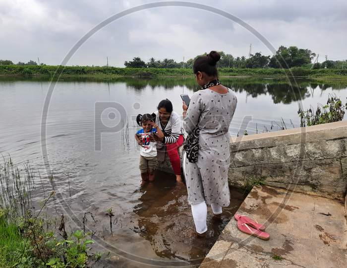 Image of Closeup Of Beautiful Indian Kid And Mother Playing In A Pond ...