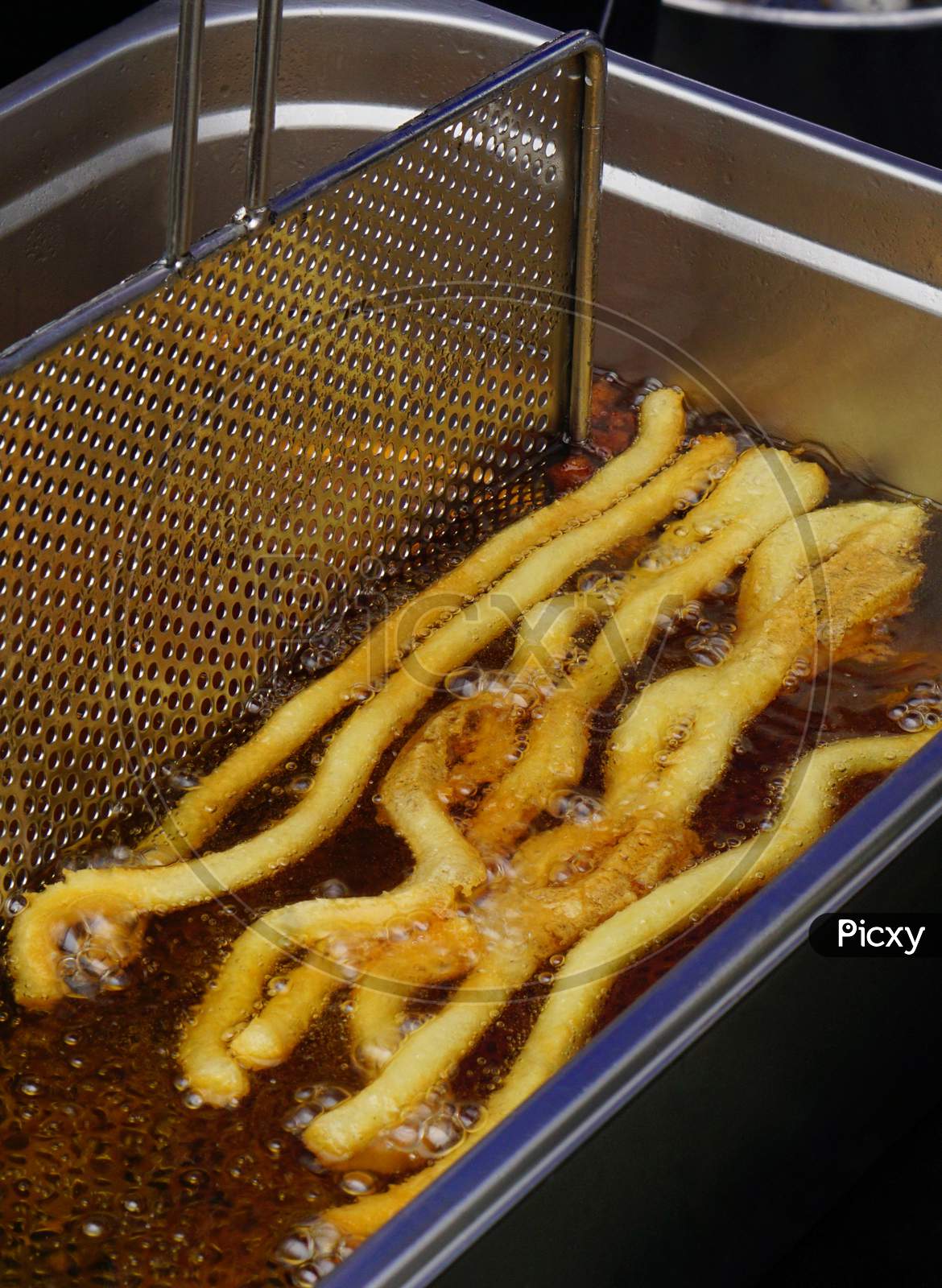 View Of Deep Frying Of Potato Chips,In Oil ,By Indian Street Food Vendor