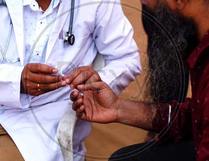 Doctor Piercing The Finger With Lancet To Take Blood Sample To Check Blood Sugar Level Of A Diabetic Patient