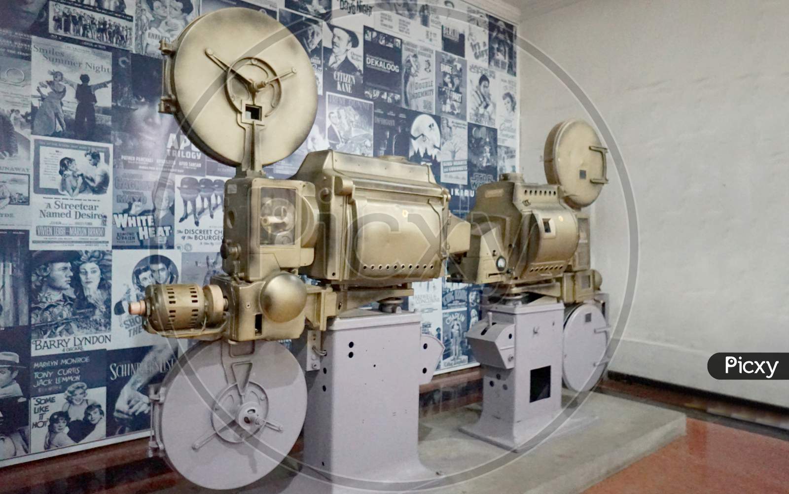 Old Antique Cinema Projector With Cine Posters In The Background.