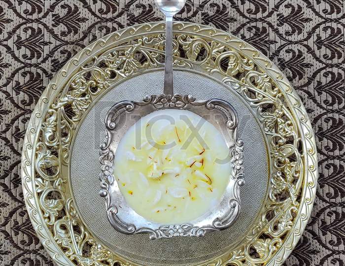 Kheer or rice pudding is an Indian dessert in a Silver bowl with dry fruits toppings
