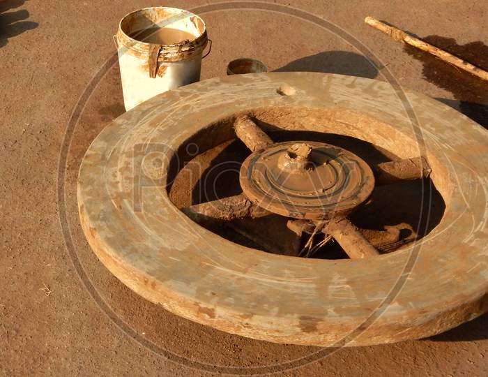 Stock Photo Of Potters Wheel, Mud And Water Bucket In Day Light