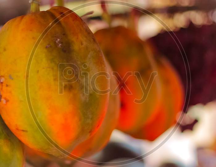 The papaya fruits on a wooden table and a rustic fabric at the