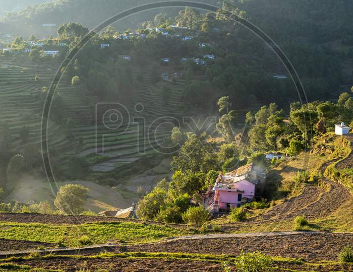 Beautiful Landscape Of A Village Based In Mountains Captured During Sunset. View Of Terrace Farms With The Crops.