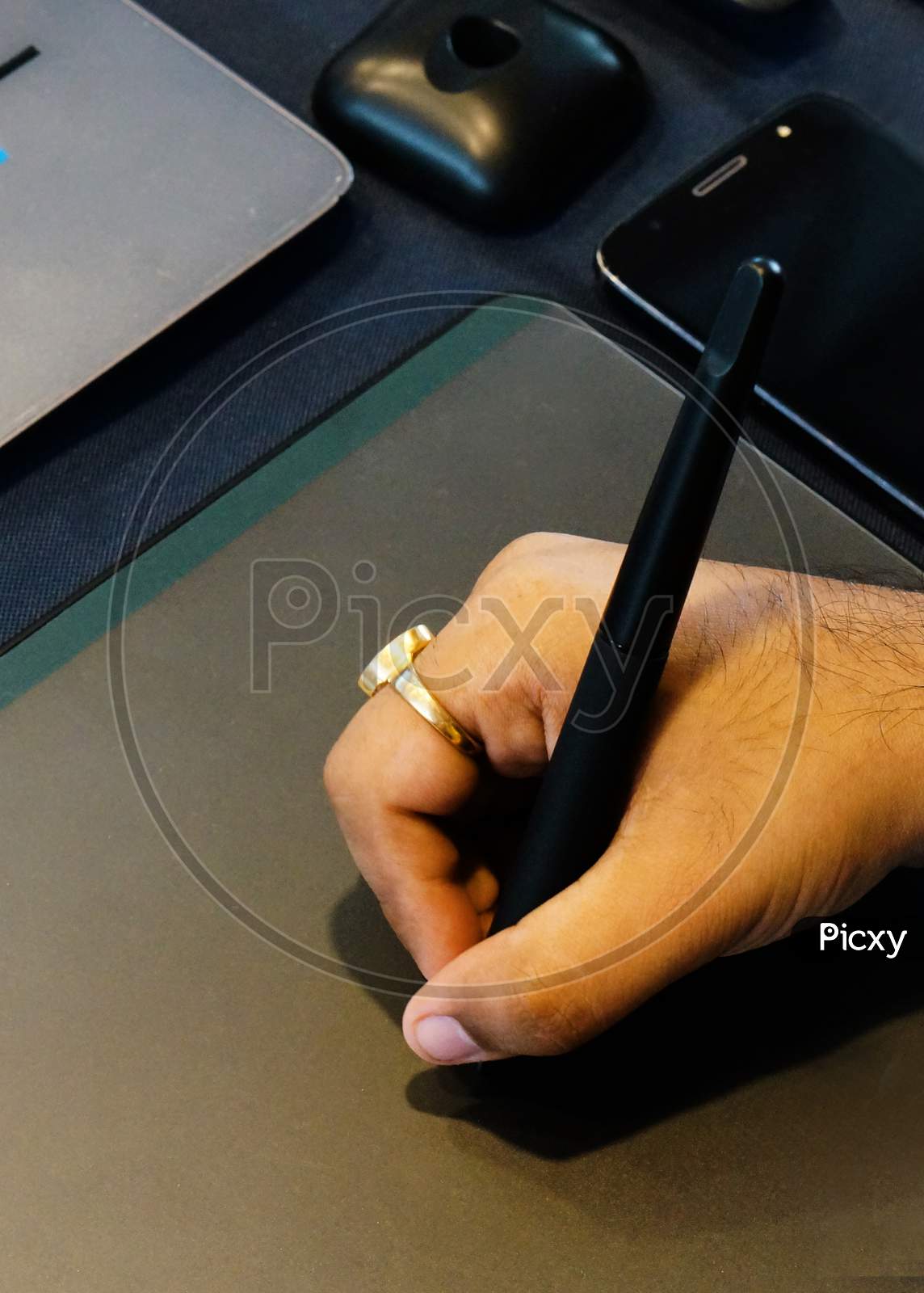 Indian Man Hand Holding Pen And Sketching On Drawing Pad