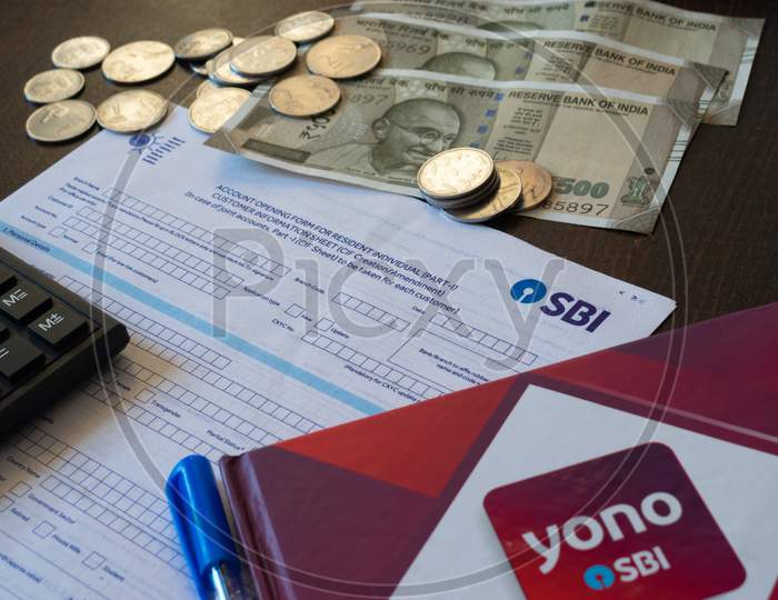 Mumbai, India - 19 October 2021, Picture of State Bank of India's account opening form along with cash, calculator, YONO brand and pen.