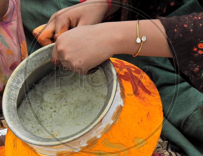 Indian Hindu Woman Decorating The Vessel, With Turmeric And Vermilion, To Offer Food To Goddess Mahan Kali  As Bonam