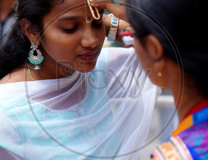 Indian Hindu Woman Apply Tilak On Fore Head Of A Devotee,A Religious Ritual,On Krisnastami Festival Celebration In God Krishna Temple