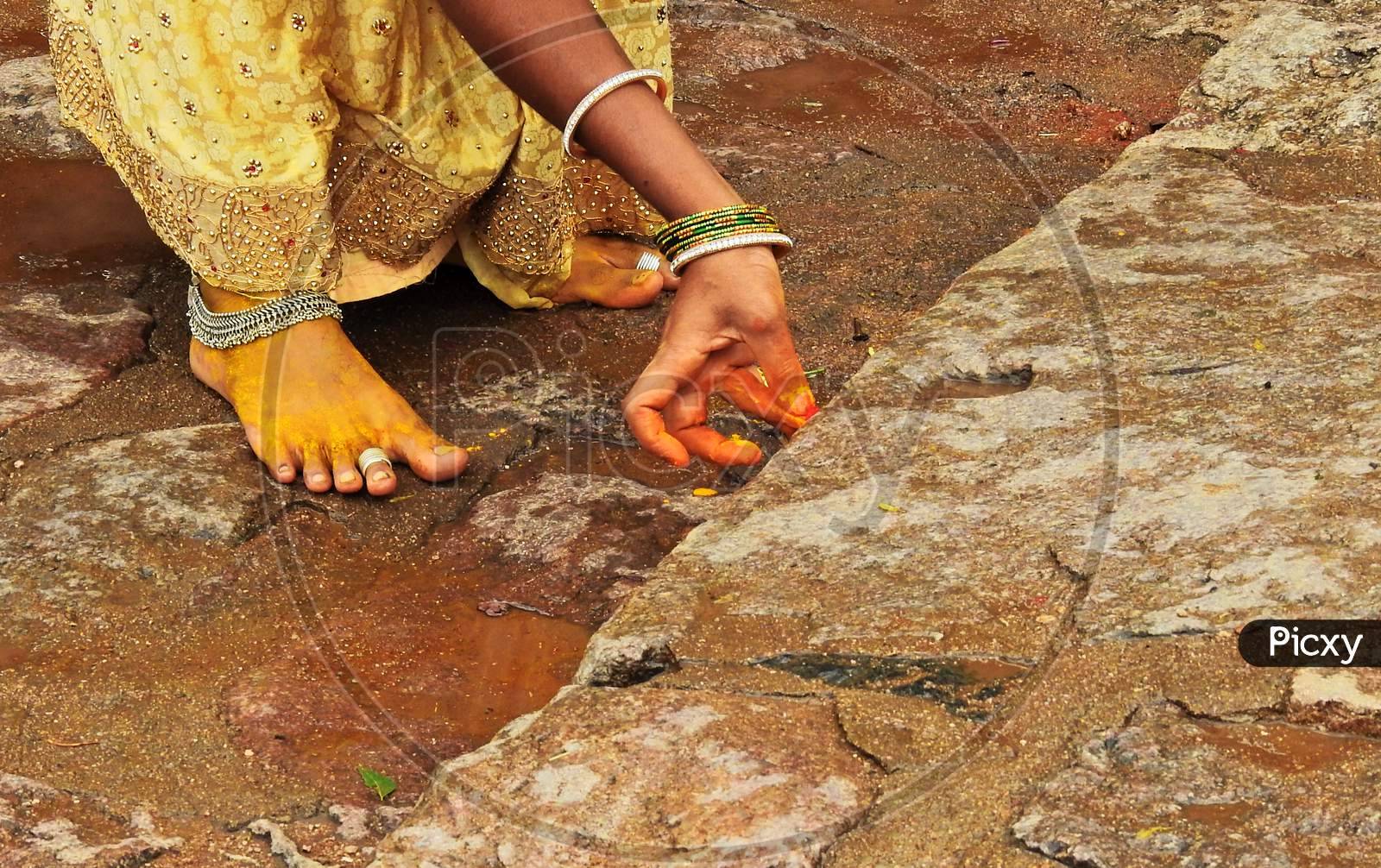 Indian Hindu Woman Applying Turmric And Vermilion To Temple Steps During Bonalu Festival