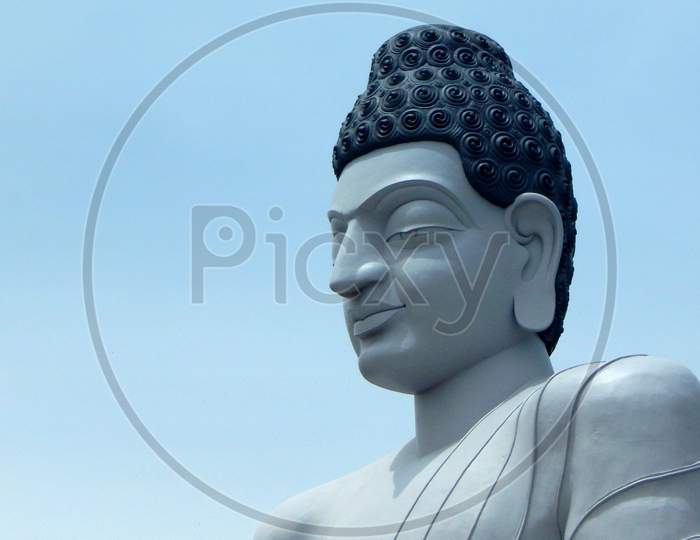 View Of Head Or Portrait Of Buddha Against Blue Sky