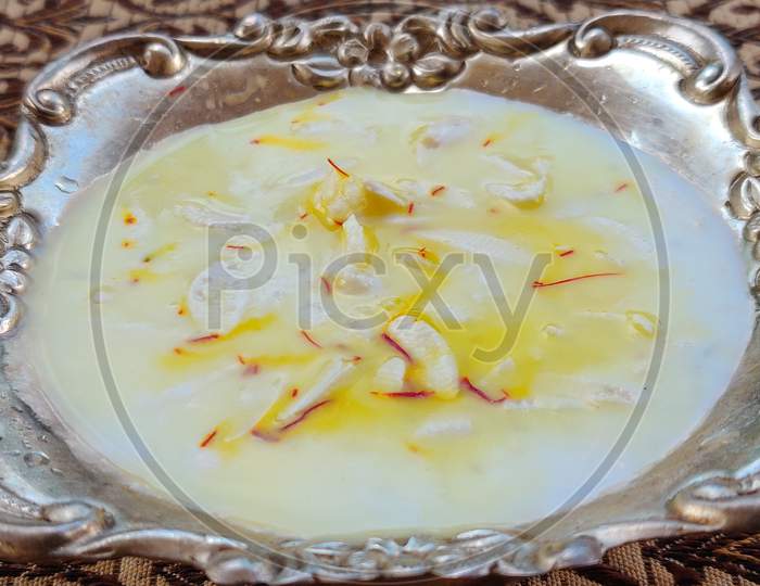 Kheer or rice pudding is an Indian dessert in a Silver bowl with dry fruits toppings