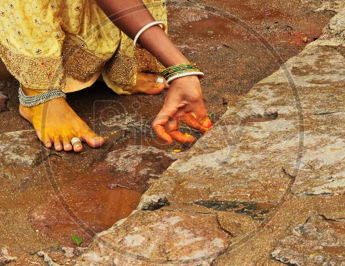 Indian Hindu Woman Applying Turmric And Vermilion To Temple Steps During Bonalu Festival