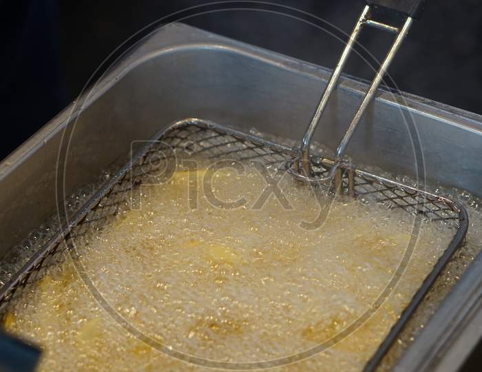View Of Deep Frying Potato Chips In Elctric Machine By Indian Street Food Vendor