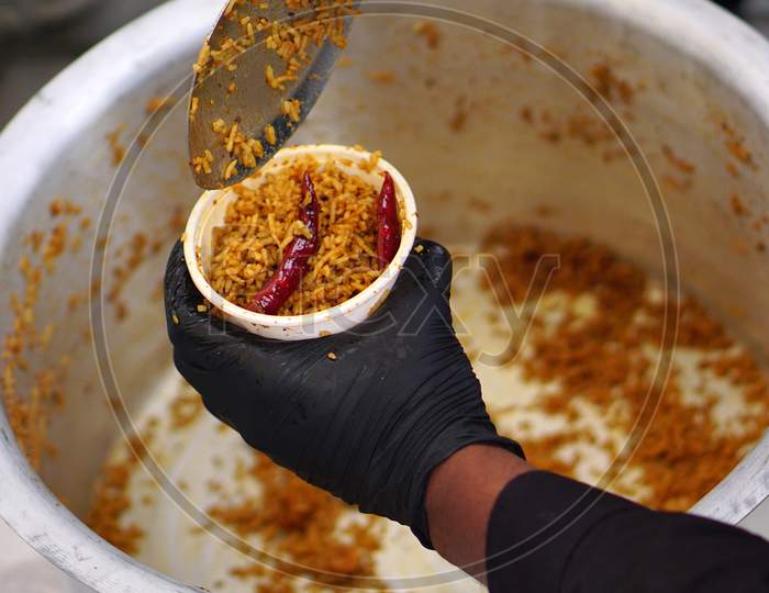 Indian Street Food Vendor Fillng Fried Rice In The Container To Serve