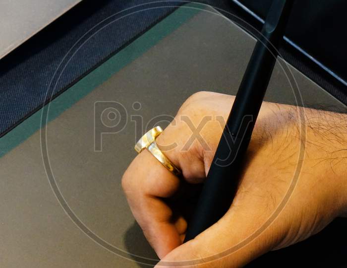 Indian Man Hand Holding Pen And Sketching On Drawing Pad