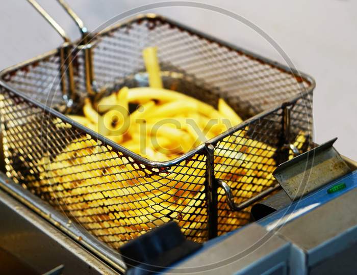View Of Deep Fried Potato French Fries In Electric Machine By Indian Street Food Vendor