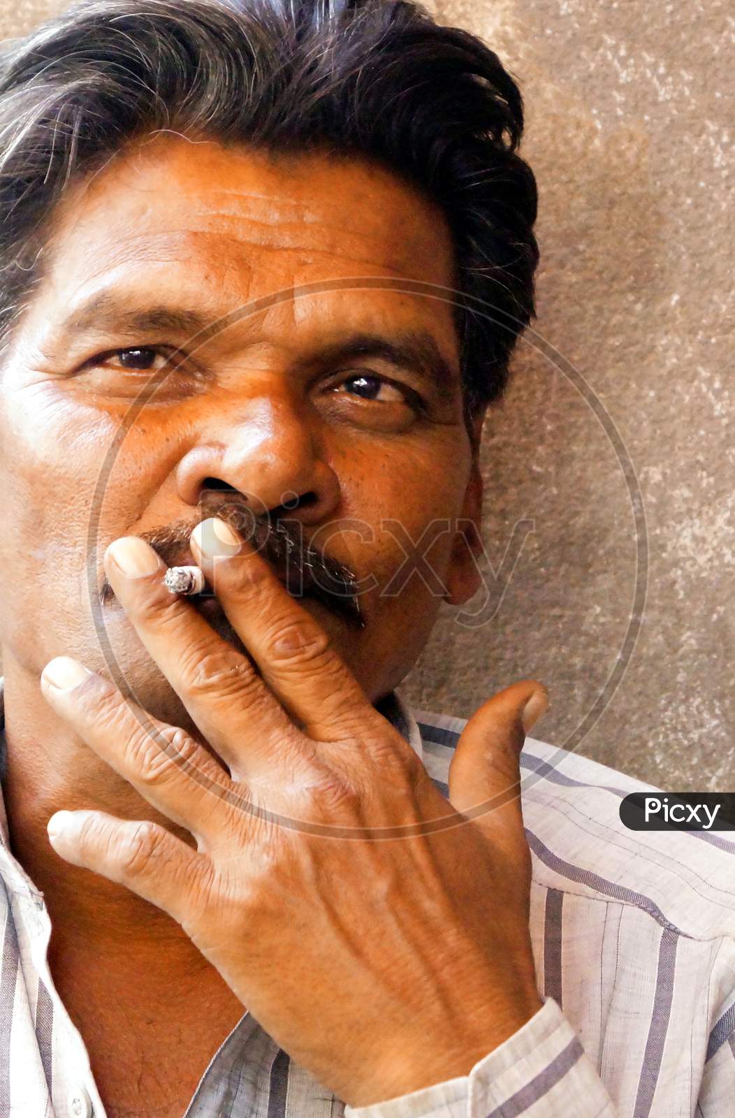 Portrait Of Indian Middle Aged Man Smoking In Outdoors