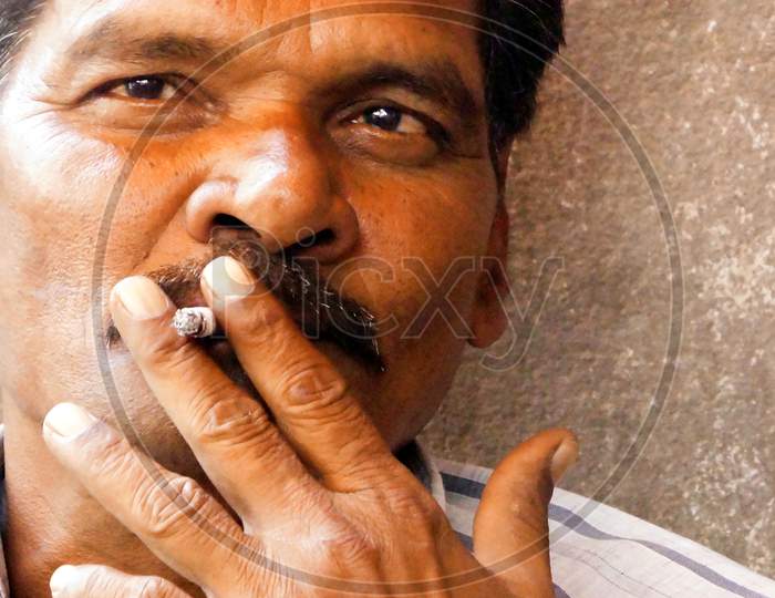 Portrait Of Indian Middle Aged Man Smoking In Outdoors