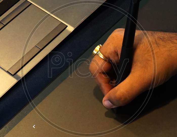 View Of Indian Man Hand Holding Pen And Sketching On Drawing Pad