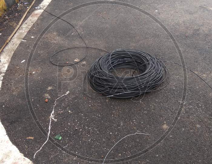 Black wire coil lay down on road