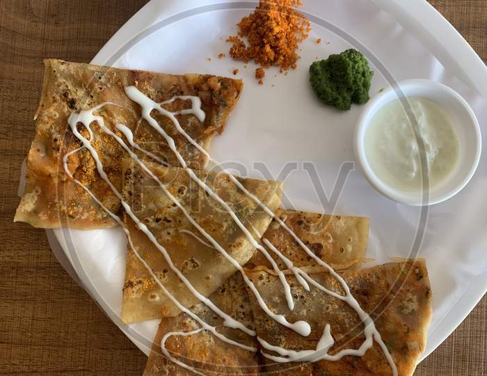 Aloo Paratha or Indian Potato stuffed Flatbread. Served with fresh curd and chutneys. selective focus