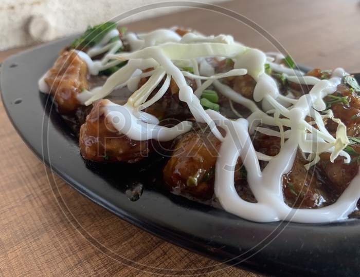 Veg Manchurian with gravy - Popular food of India made of cauliflower florets and other vegetable with myonese sauce over it. Selective focus.