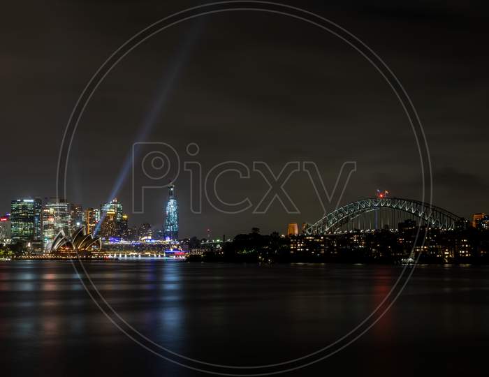 Sydney, Australia - 10th February 2020: A German photographer visiting Sydney in Australia, taking pictures of the skyline with the Opera house during a cloudy but warm day in summer at night.
