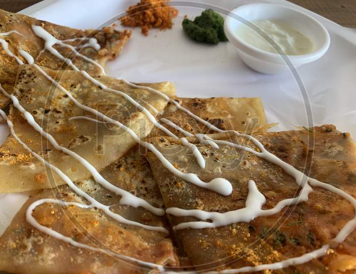 Aloo Paratha or Indian Potato stuffed Flatbread. Served with fresh curd and chutneys. selective focus