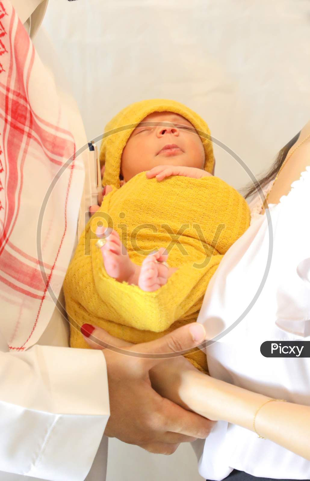 Cute Arabic Girl In Yellow Blanket And Head Scarf Lying In Parents Hands Newborn Baby Wallpaper