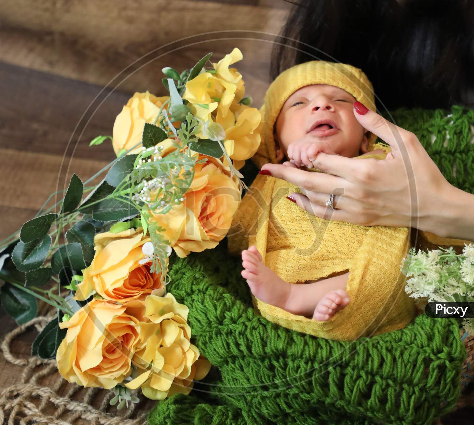 Cute Girl Covered With Yellow Blanket And Head Scarf Lying On Green Knit Textile Yellow Flowers