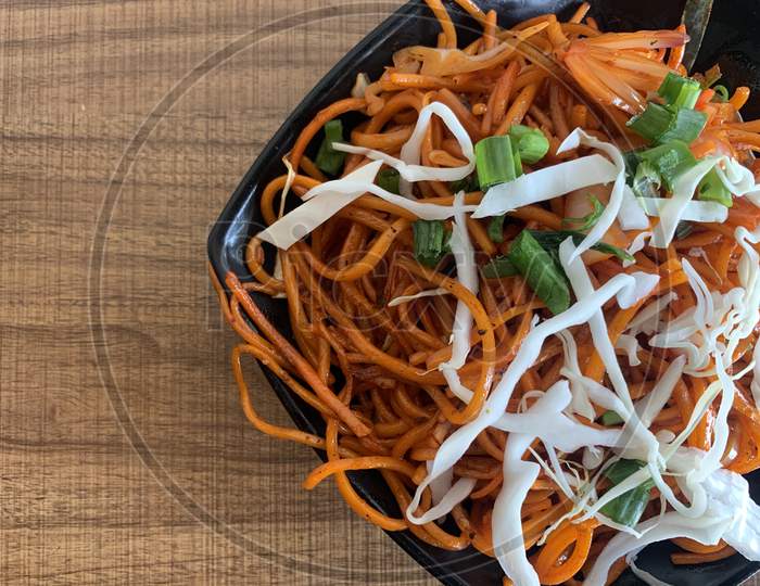 Vegetarian Schezwan Noodles or Vegetable Hakka Noodles or Chow Mein in bowl. Schezwan Noodles is indo-chinese cuisine hot dish with noodles, vegetables and chilli sauce