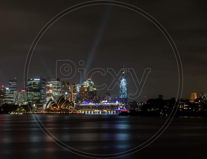 Sydney, Australia - 10th February 2020: A German photographer visiting Sydney in Australia, taking pictures of the skyline with the Opera house during a cloudy but warm day in summer at night.
