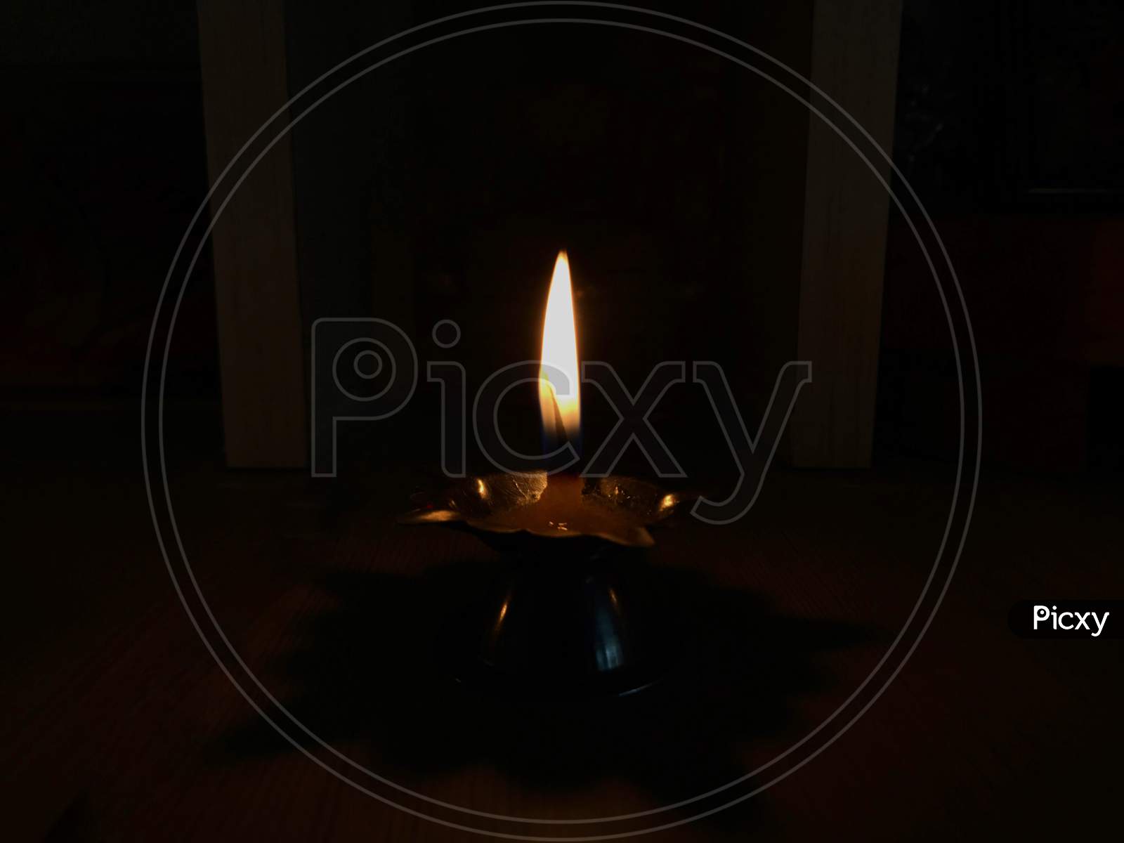 Small diya lamp burning with an orange flame
