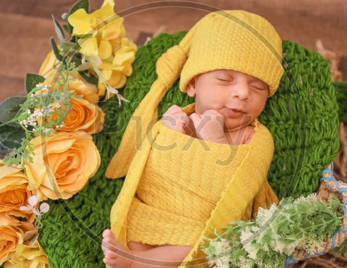 Cute Girl Covered With Yellow Blanket And Head Scarf Lying On Green Knit Textile Yellow Flowers