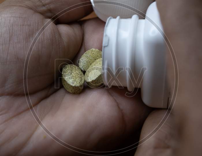 Image Of Tablets Or Medicine Taken On Palm From Bottle Before Consuming.