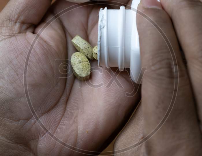 Image Of Tablets Or Medicine Taken On Palm From Bottle Before Consuming.