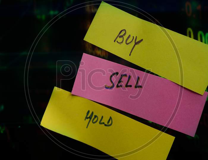 Concept Of Buy Sell Hold Written On Sticky Notes Attached On Share Market Graph.
