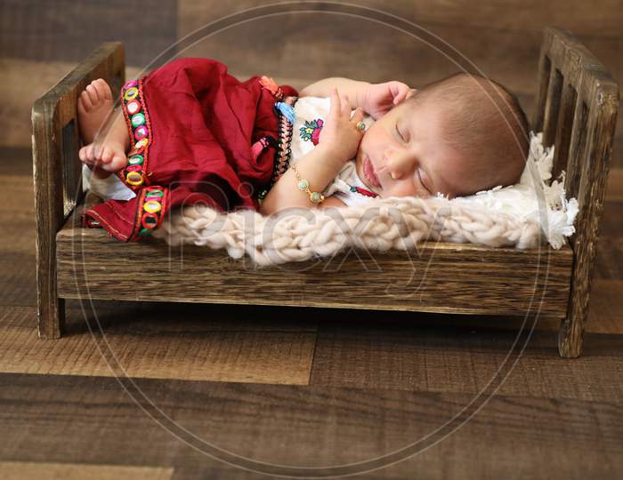 Beautiful Little Girl Sleeping And Posing On Wooden Baby Bed Colorful Floral Dressing