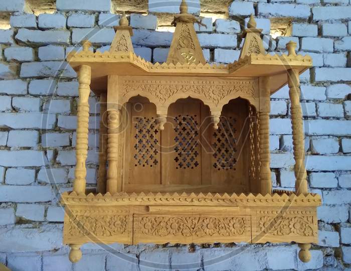 Wooden temple model with blue wall in background