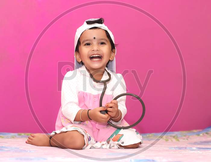 Cute little girl playing doctor with stethoscope