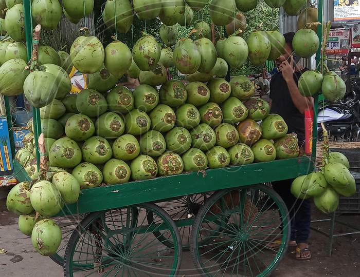 Green coconuts selling on hand kart