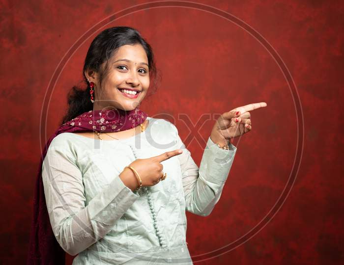 Happy Smiling Indian Woman Pointing Finger To Empty Space By Looking At Camera - Cocnept Of Showing Offers Or Discounts For Festival Sales Advertisement With Copy Space.
