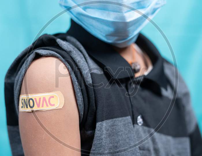 Maski, India - October 26, 2021 : Kid With Medical Face Mask Showing Sinovac Vaccine Bandage On Shoulder, Coronavirus Or Covid Vaccination For Children From China.
