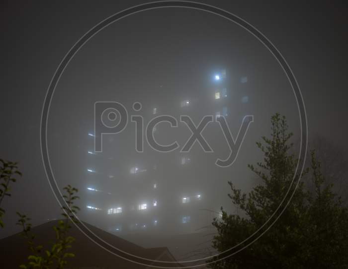 Eerie Sky Scraper Hospital Lights Shine Through Very Thick Fog.